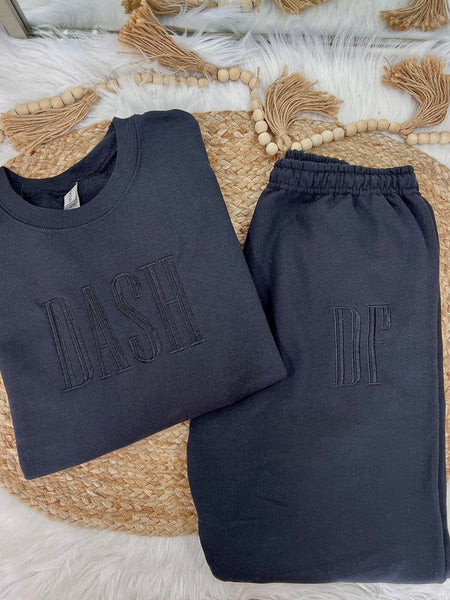 Navy blue sweatshirt and pants with 'DASH' and 'DF' text on a woven mat.