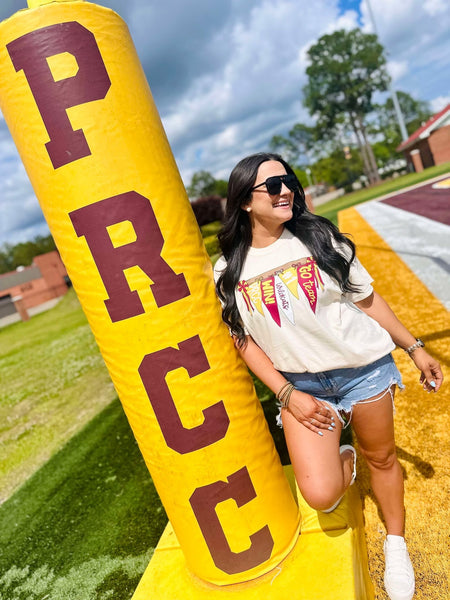 Woman posing with a large yellow and red 'PRC' inflatable tube on a grassy field.