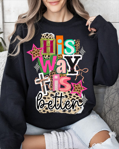 Person wearing a black sweatshirt with colorful text and patterns saying "His way is better" song lyrics