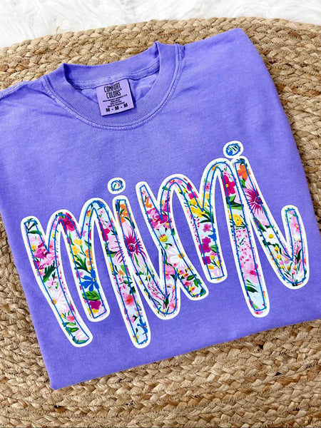 Violet Purple Comfort Color tee sweatshirt with floral pring 'MiMi' dtf graphic text on a textured surface